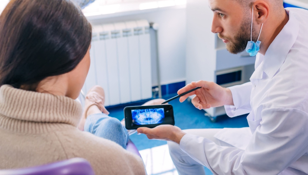 A dentist using the OrthoPhoto app on his phone